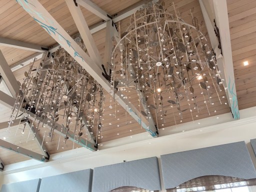 Fish-inspired hanging light fixtures beneath the pale wood ceiling at Sebastian's Bistro