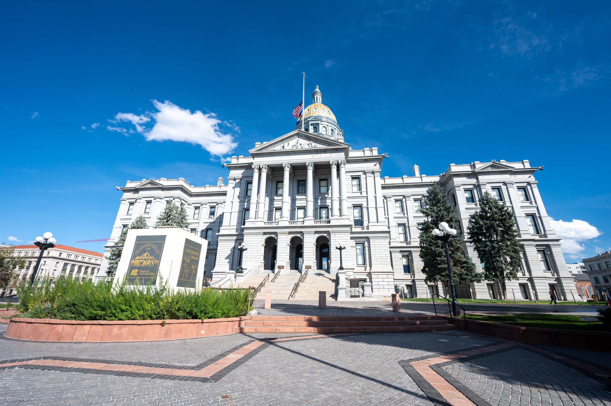 Colorado State Capitol with its gold dome against a blue sky.