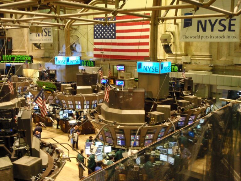 The New York Stock Exchange trading floor seen from the Member's Gallery, with trading posts, desks, screens and United States flags