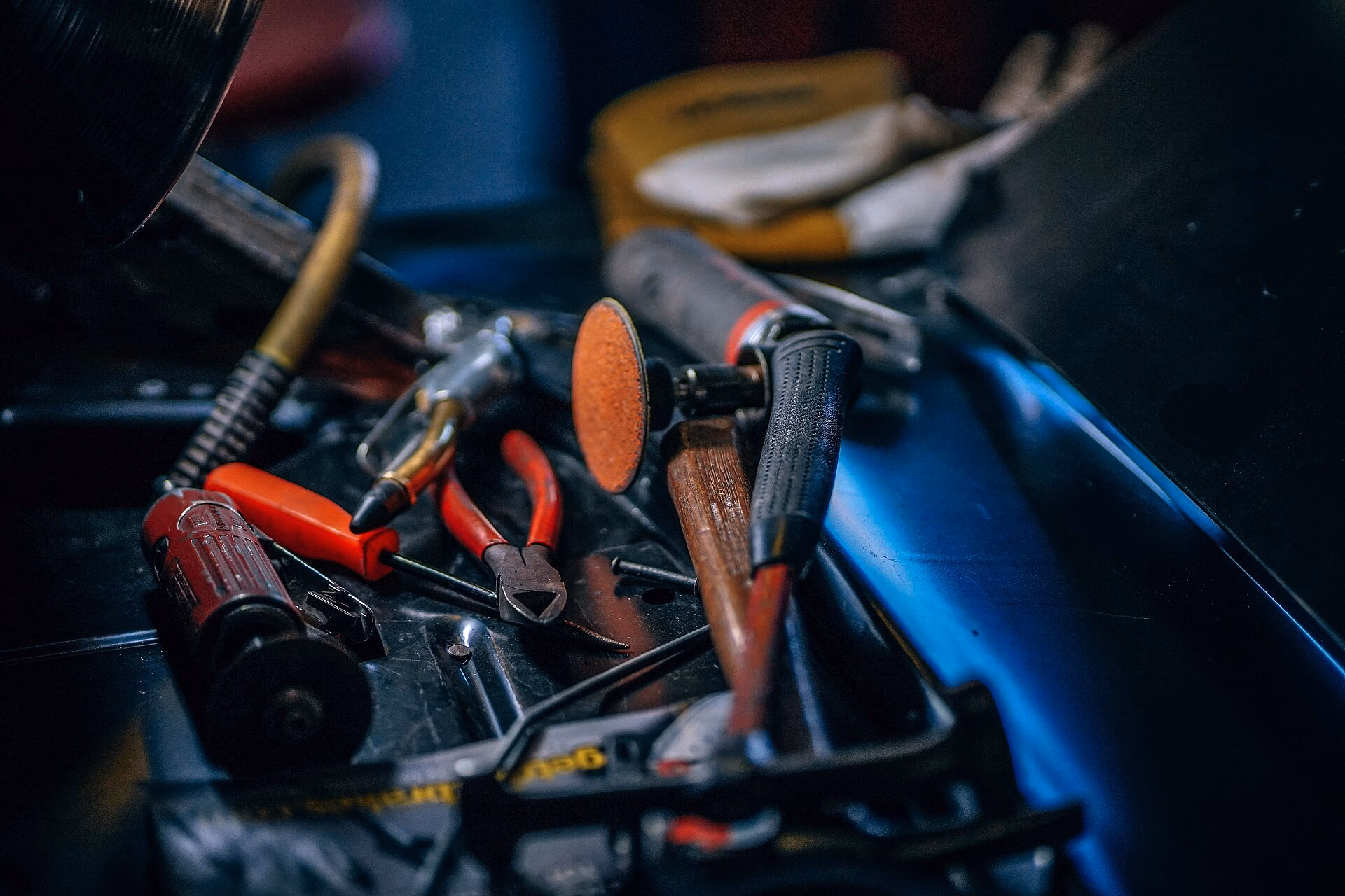 Hand tools and a rotary tool arranged in a dark work tray.