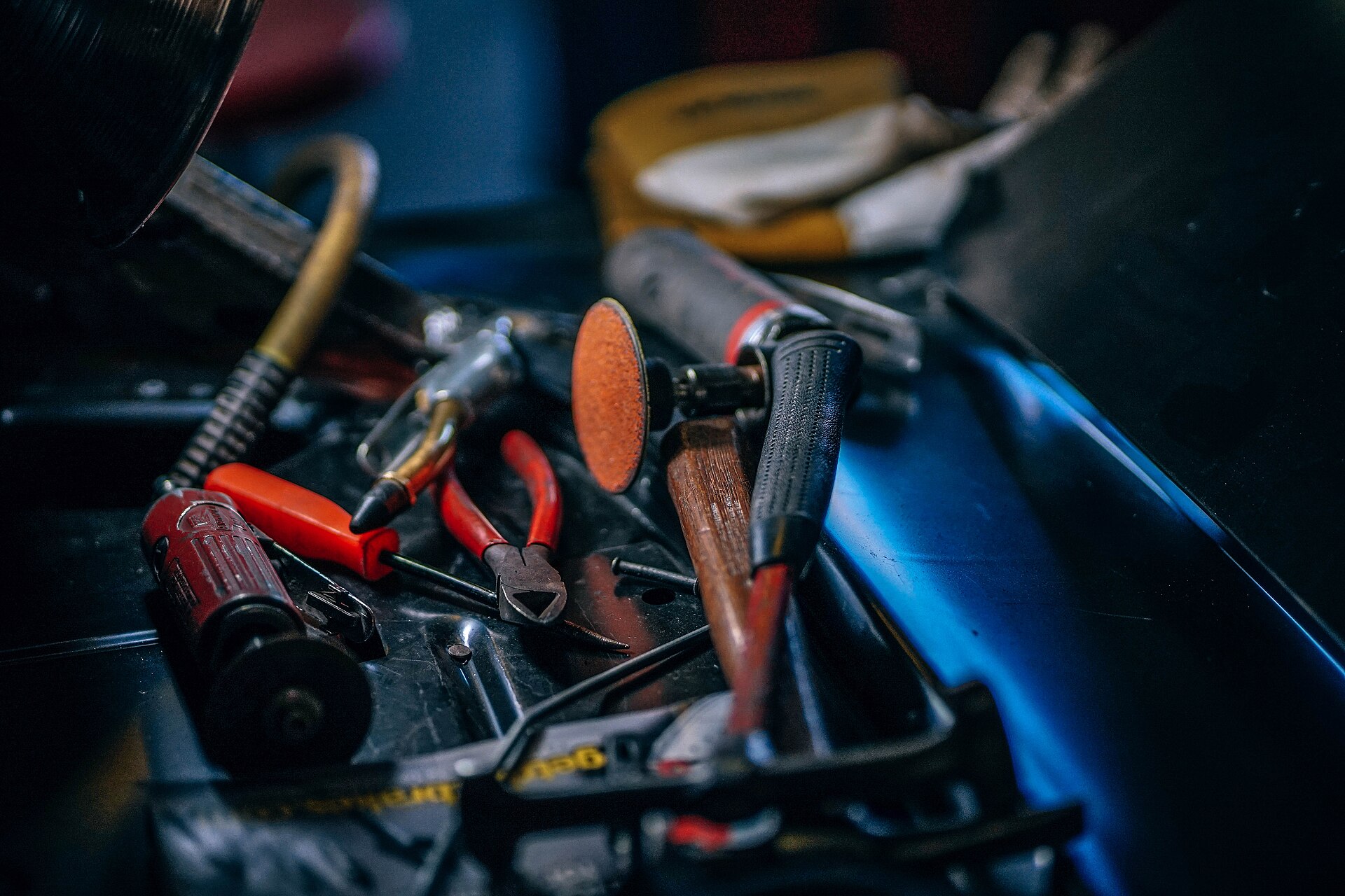 Hand tools and a rotary tool arranged in a dark work tray.