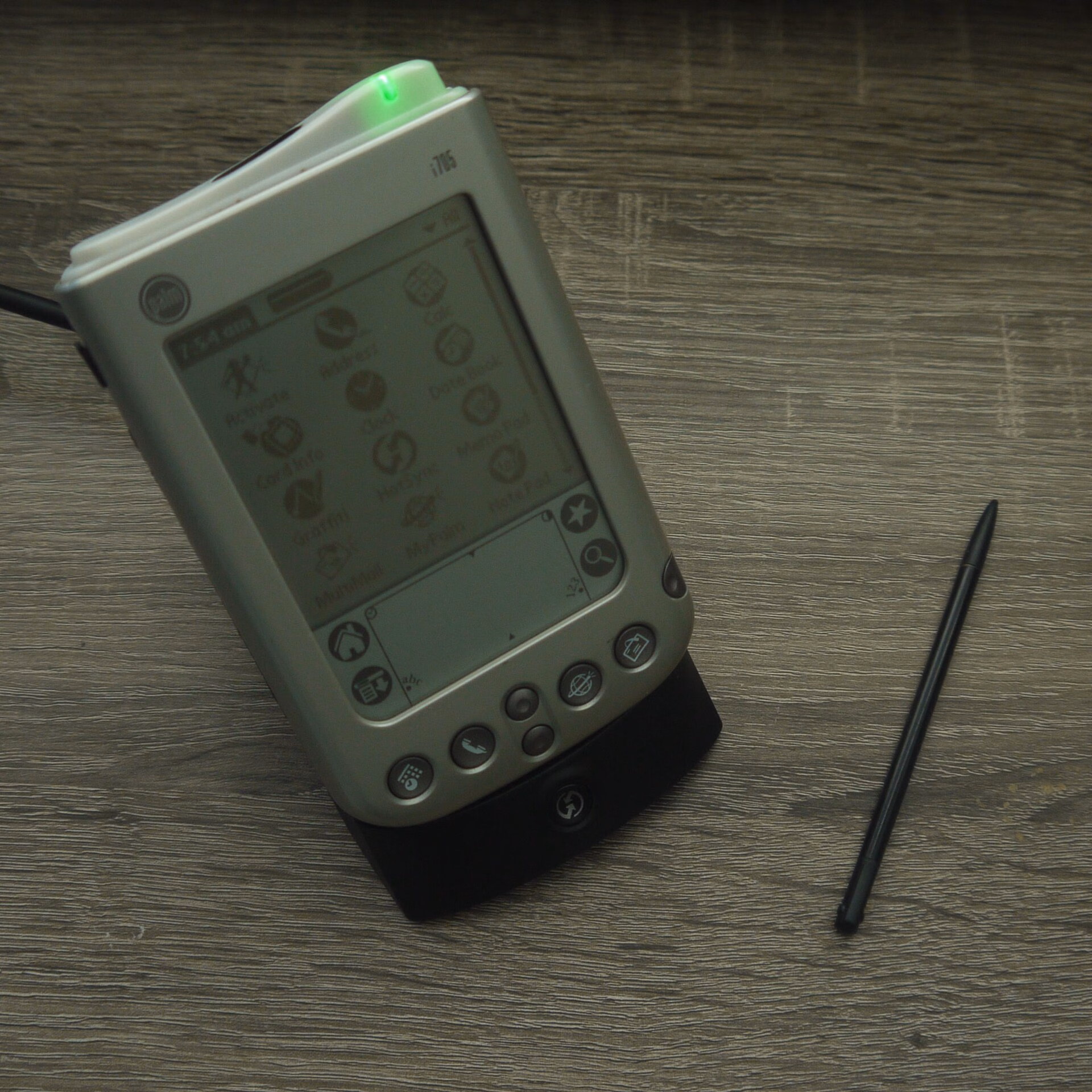 Palm i705 PDA in a docking cradle