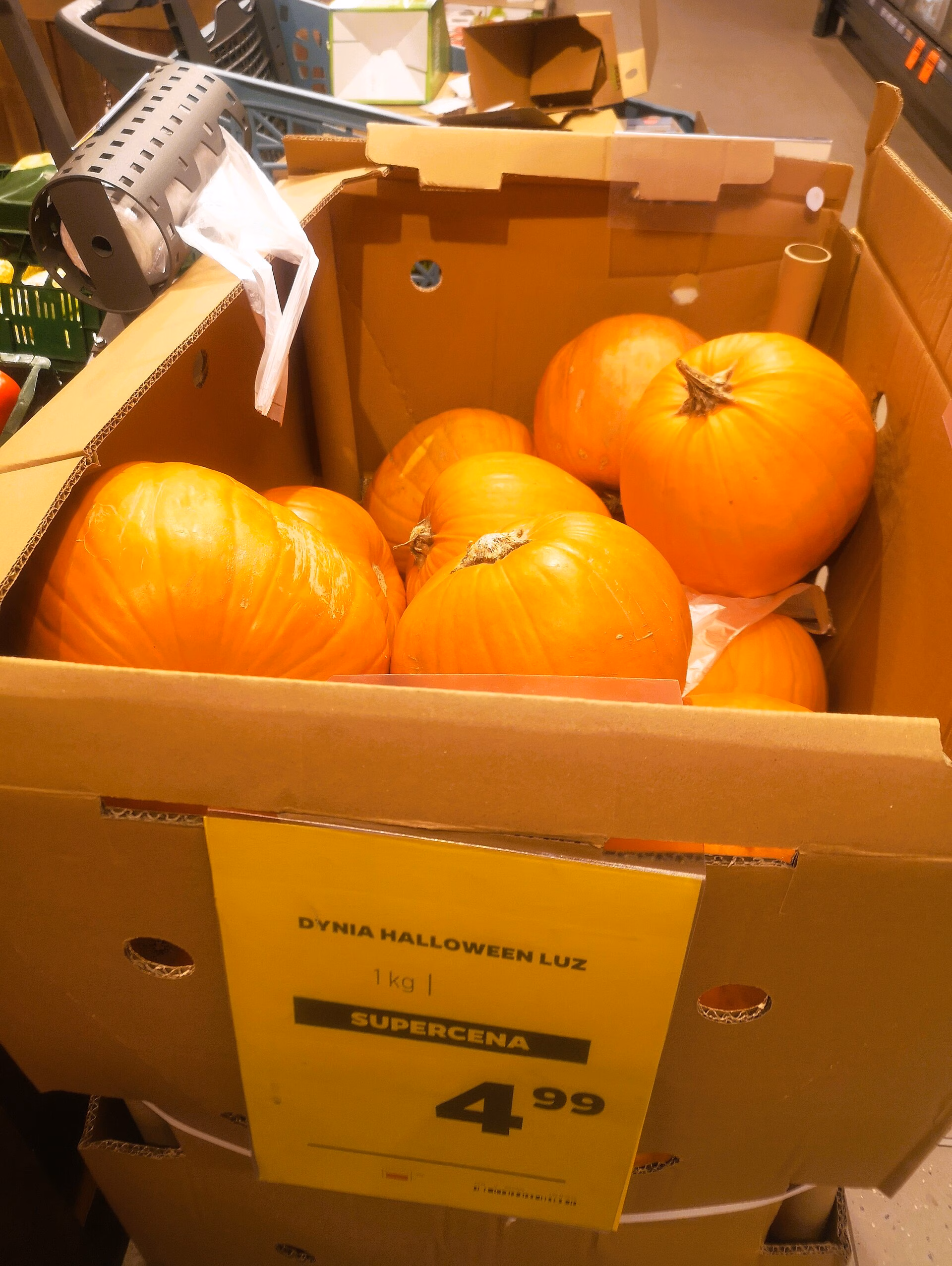 A bin of bright orange Halloween pumpkins for sale