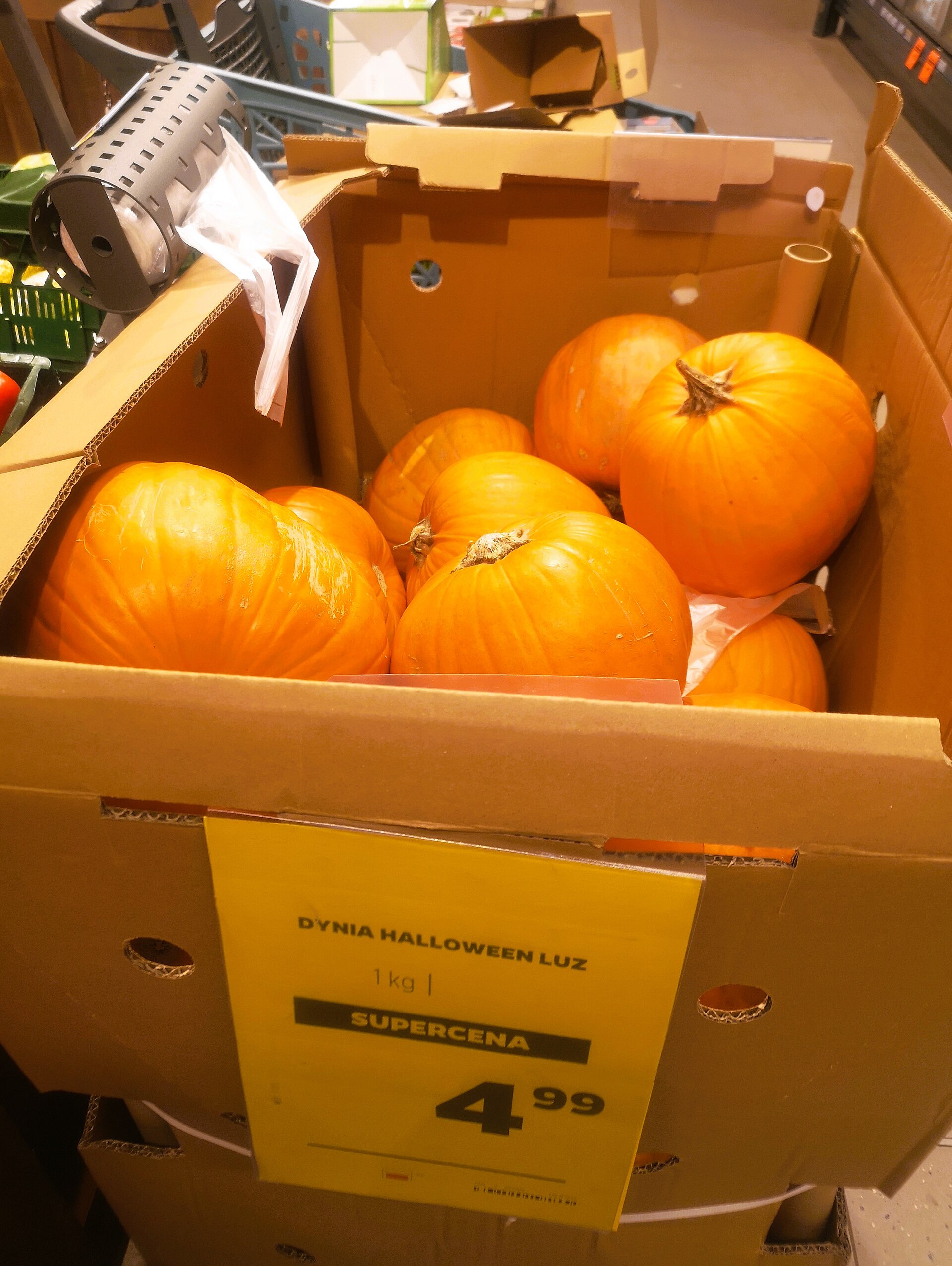 A bin of bright orange Halloween pumpkins for sale