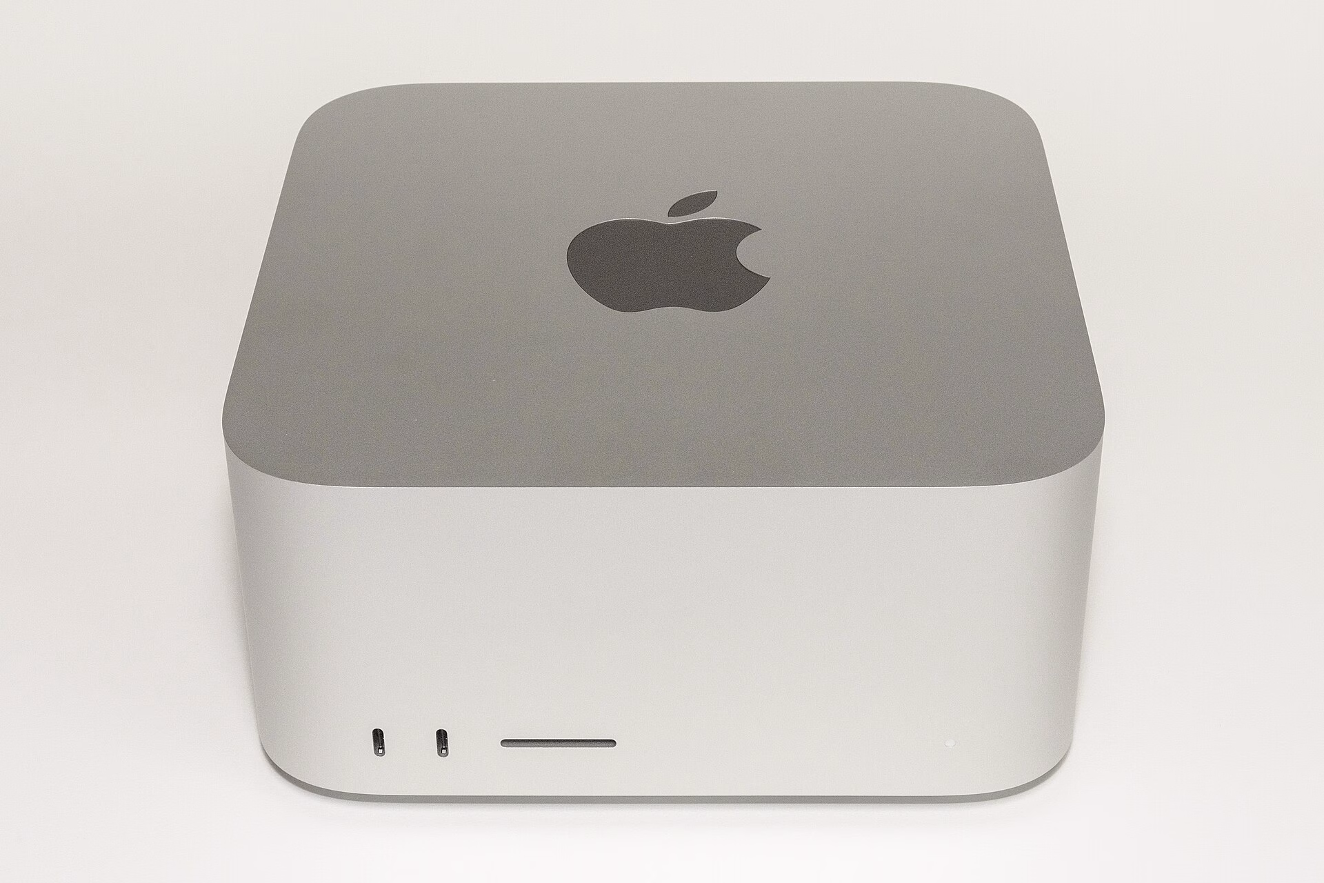Front view of a silver Mac Studio with its two front USB-C ports and SD card slot visible.