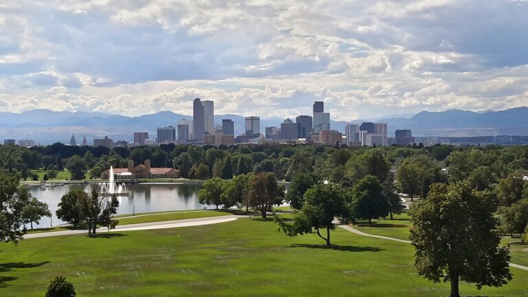 Downtown Denver skyline seen from City Park with the Front Range of the Rocky Mountains on the horizon