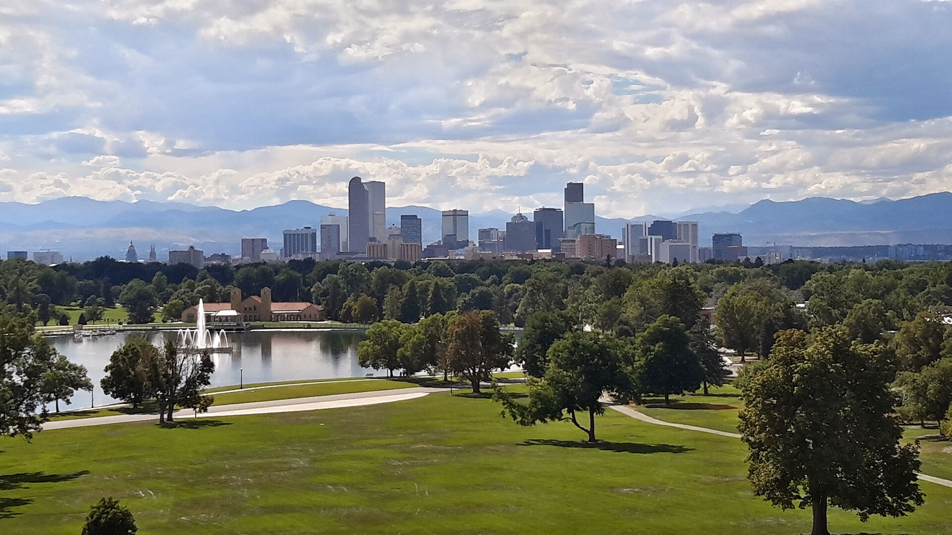 Downtown Denver skyline seen from City Park with the Front Range of the Rocky Mountains on the horizon