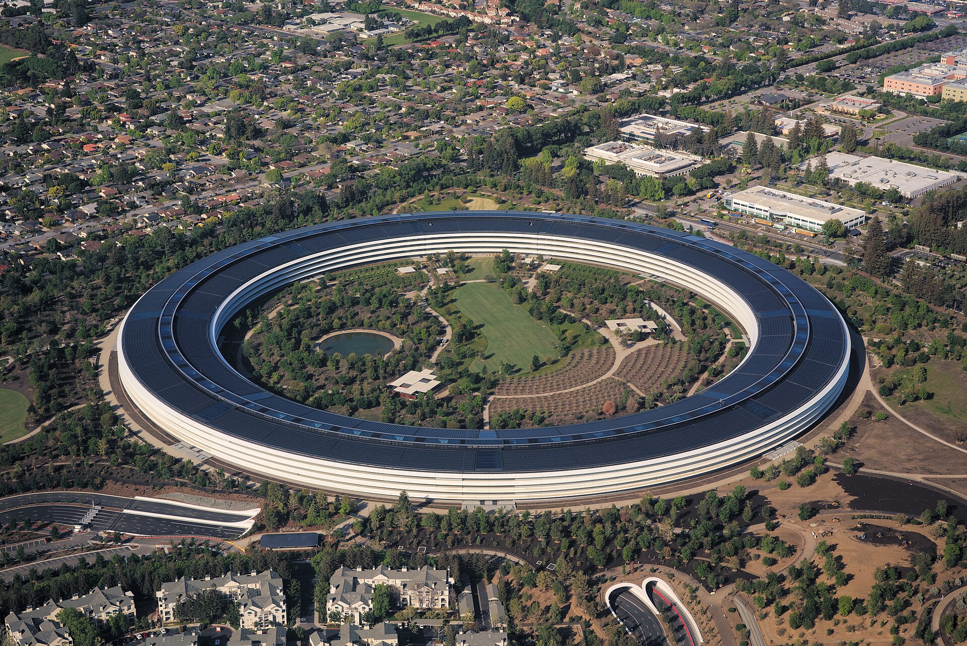 Aerial view of Apple Park, Apple Inc.'s ring-shaped headquarters in Cupertino, California, its circular building and solar-panel roof surrounded by trees