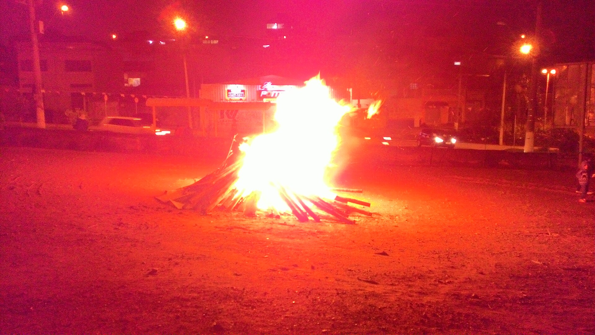 Large fire pit filled with logs at a community gathering
